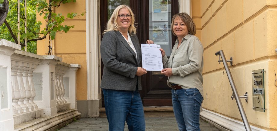 Die städtische Beigeordnete Margit Gronen (links) und Heidi König, Mitarbeiterin der Stadt Boppard, mit dem Zuwendungsbescheid über Mittel aus dem Förderprogramm für „Klimaangepasstes Waldmanagement“.