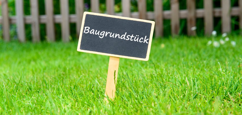 Ein Schild weist auf ein Baugrundstück hin.