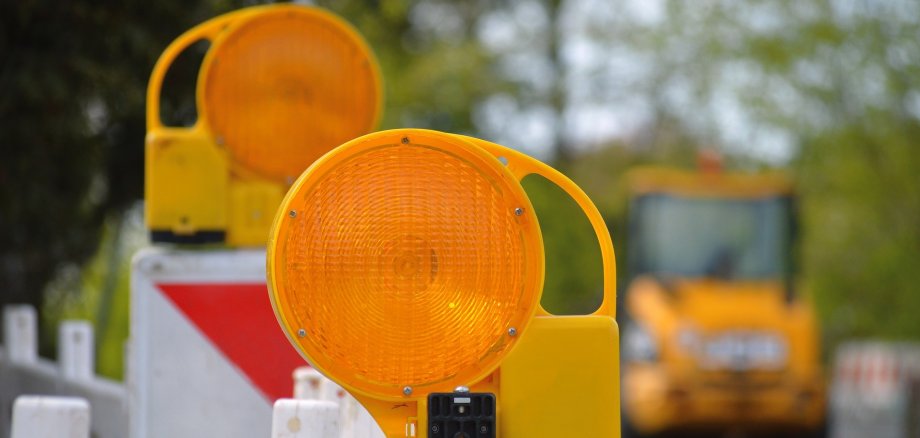 Straßensperrung, im Hintergrund stehen Baumaschinen