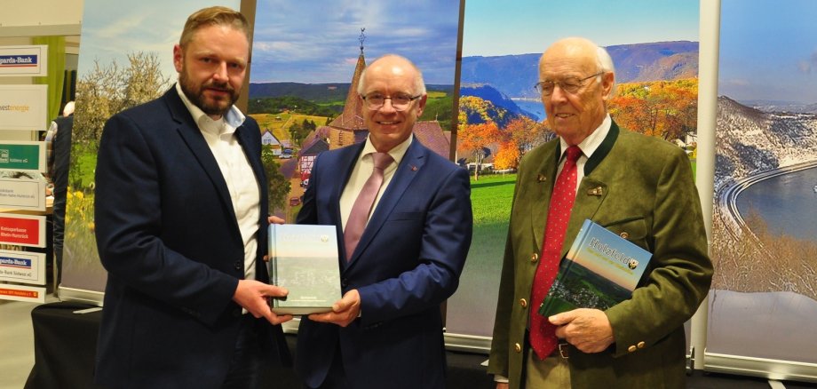 Das Foto zeigt Boppards Bürgermeister Jörg Haseneier gemeinsam mit dem Holzfelder Ortsvorsteher und dem Auto der Chronik.