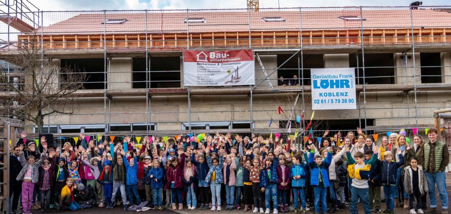 Auf dem Foto sind die Kinder der Grundschule Bad Salzig und das Lehrerkollegium, Bürgermeister Jörg Haseneier und weitere geladene Gäste zu sehen.