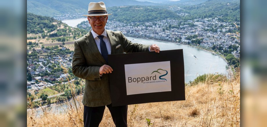 Vom Gedeonseck bietet sich ein einmaliger Ausblick auf die Stadt Boppard: Mit dem neuen Leitspruch „Mit den besten Aussichten“ präsentiert sich auch das neu gestaltete Logo der Stadtverwaltung, das Boppards Bürgermeister Jörg Haseneier an dieser Stelle präsentiert.