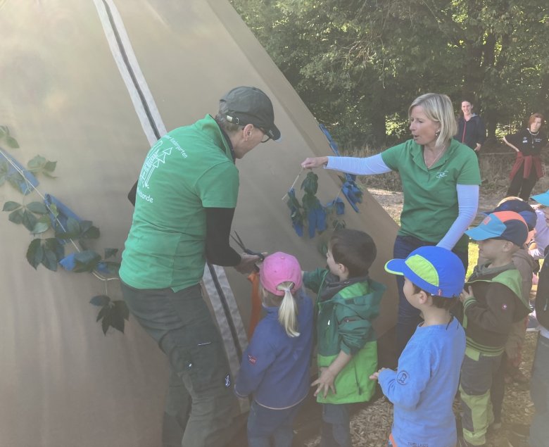 Die Projektinitiatorin Christine Jakob (links) schneidet mit einigen Kindern und Janine Jacobs feierlich das Schmuckbanddurch, um das Zelt zur Besichtigung freizugeben.